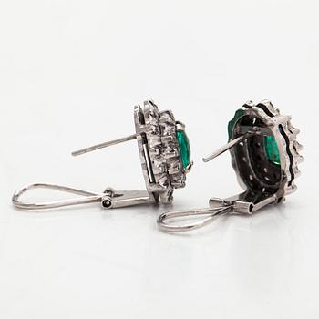 A pair of 14K whitegold earrings set with emeralds and diamonds.