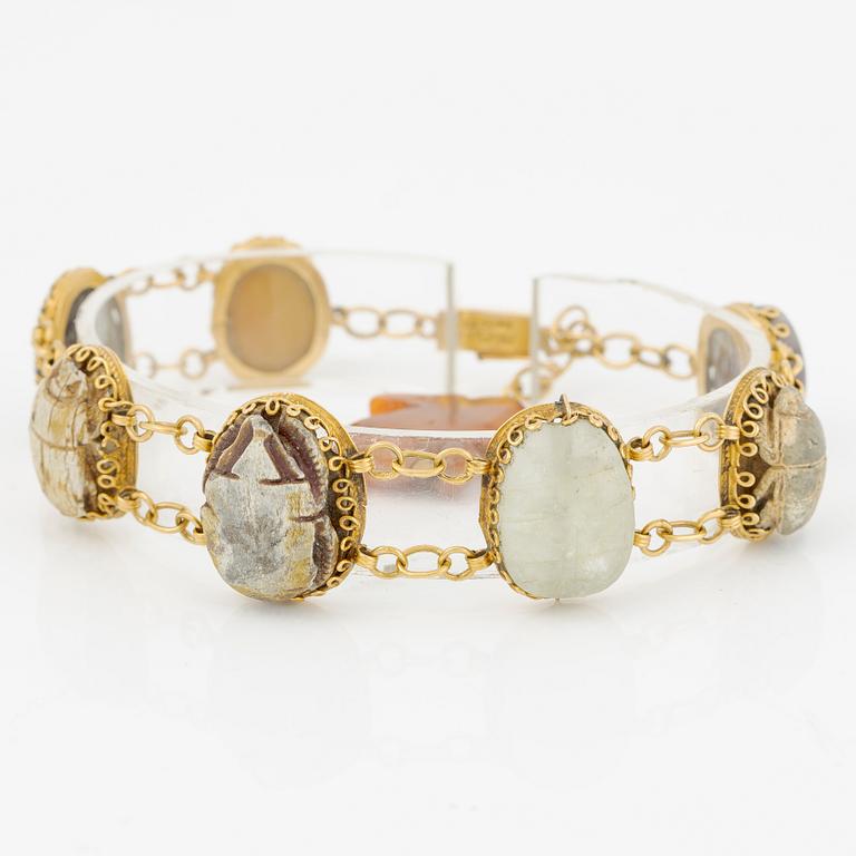 Bracelet in 14K gold with various minerals and scarab-shaped charms.