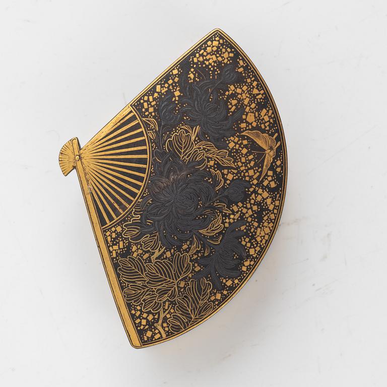 A Japanese gilt-bronze fan-shaped box and gilt iron tsuba with mei inscription, Meiji period (1868-1912).