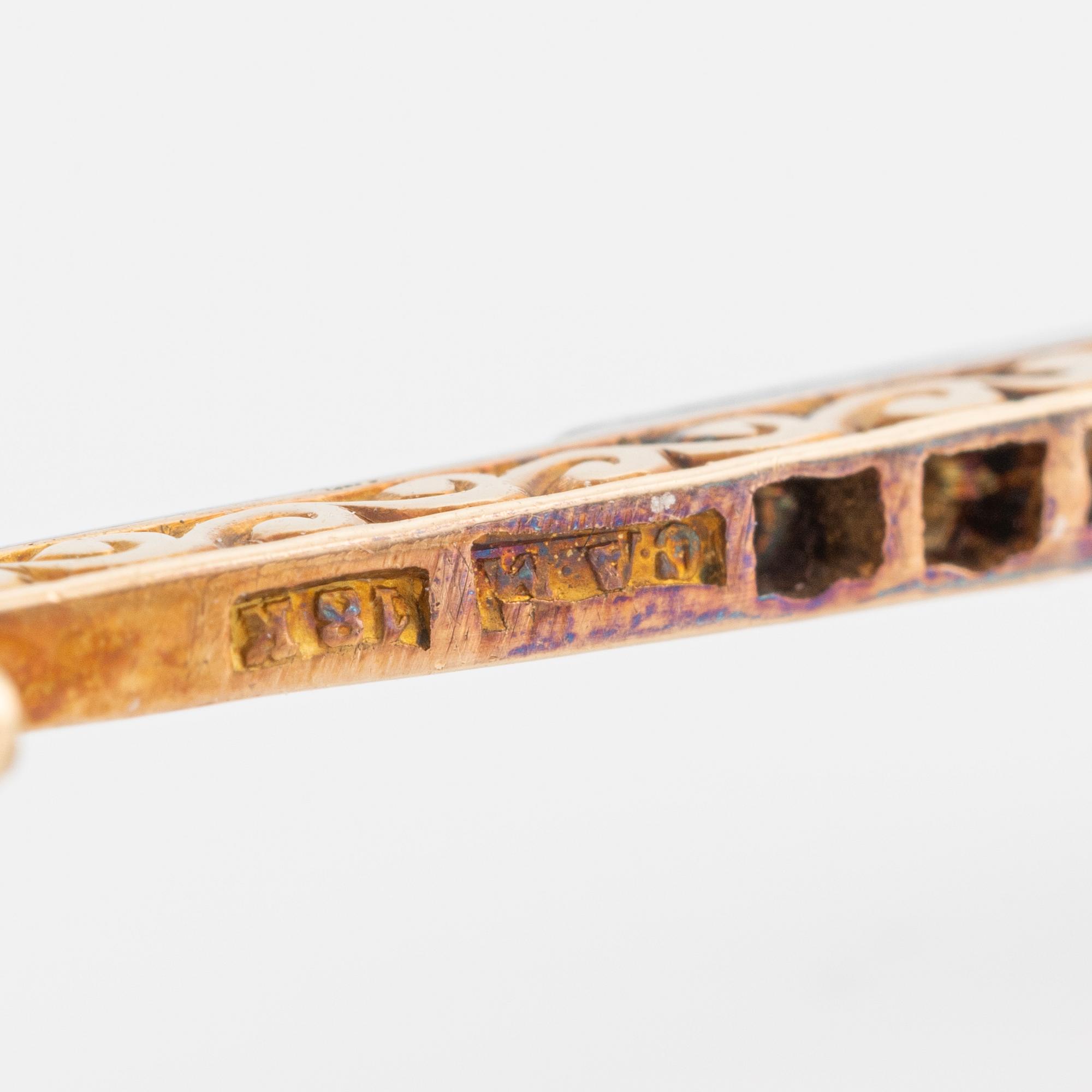 An 18K gold brooch set with a turquoise and old-cut diamonds.