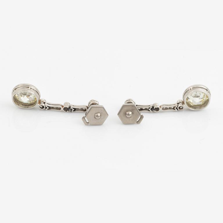 A pair of platinum earrings with two larger old-cut diamonds.