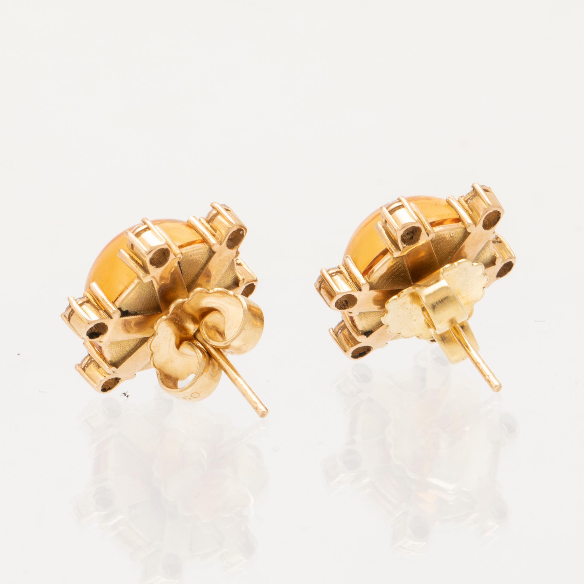 A pair of 18K gold earrings set with cabochon cut citrines and round brilliant cut diamonds.