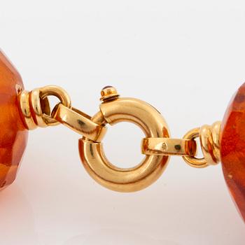 An amber necklace comprising graduated faceted amber beads ca 40 - 50 mm.