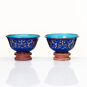 A pair of gilt decorated blue ground painted enamel bowls, Qianlong four character seal mark and period (1736-95).