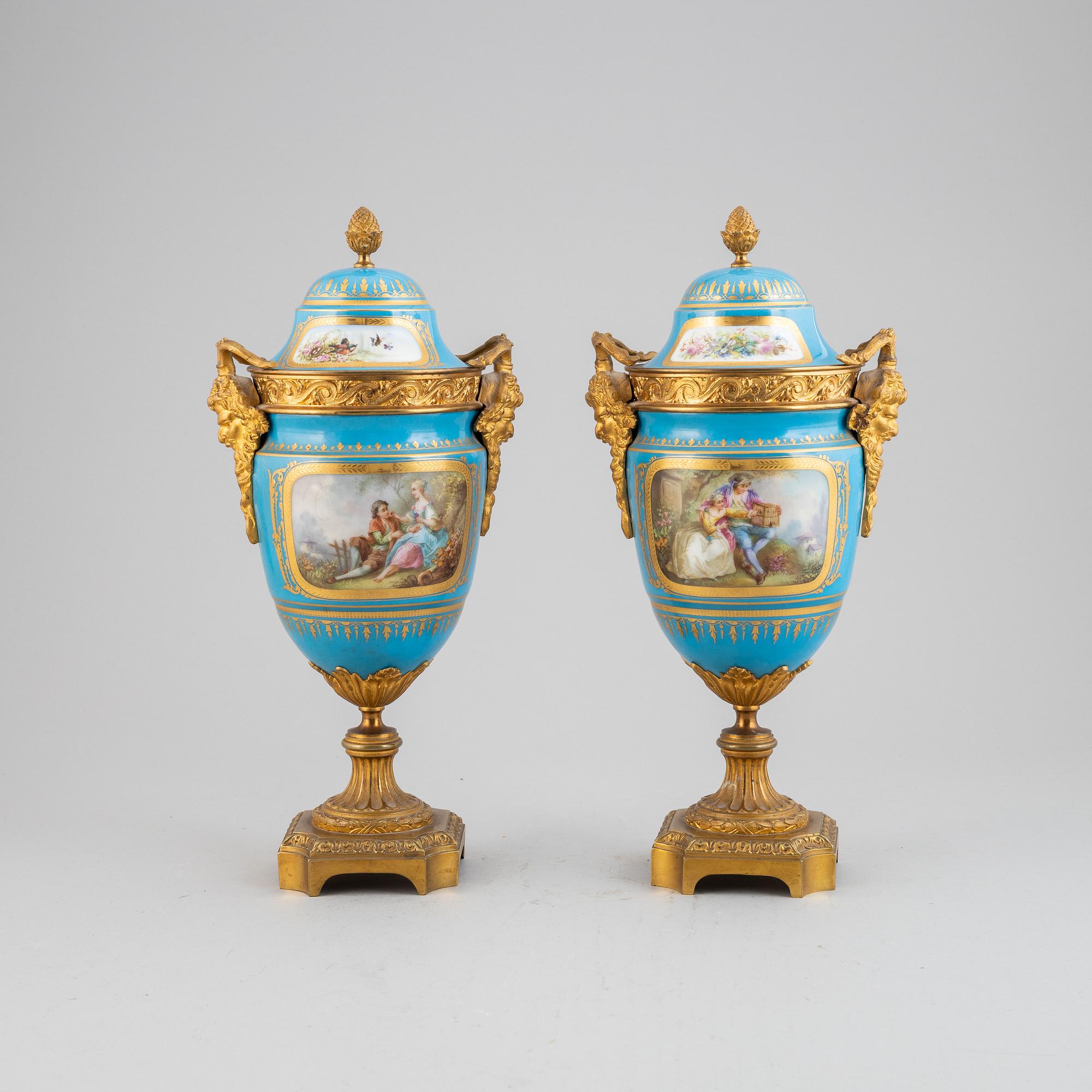 A pair of pordelain and gilt brass urns in teh style of Sevres, 20th Century.
