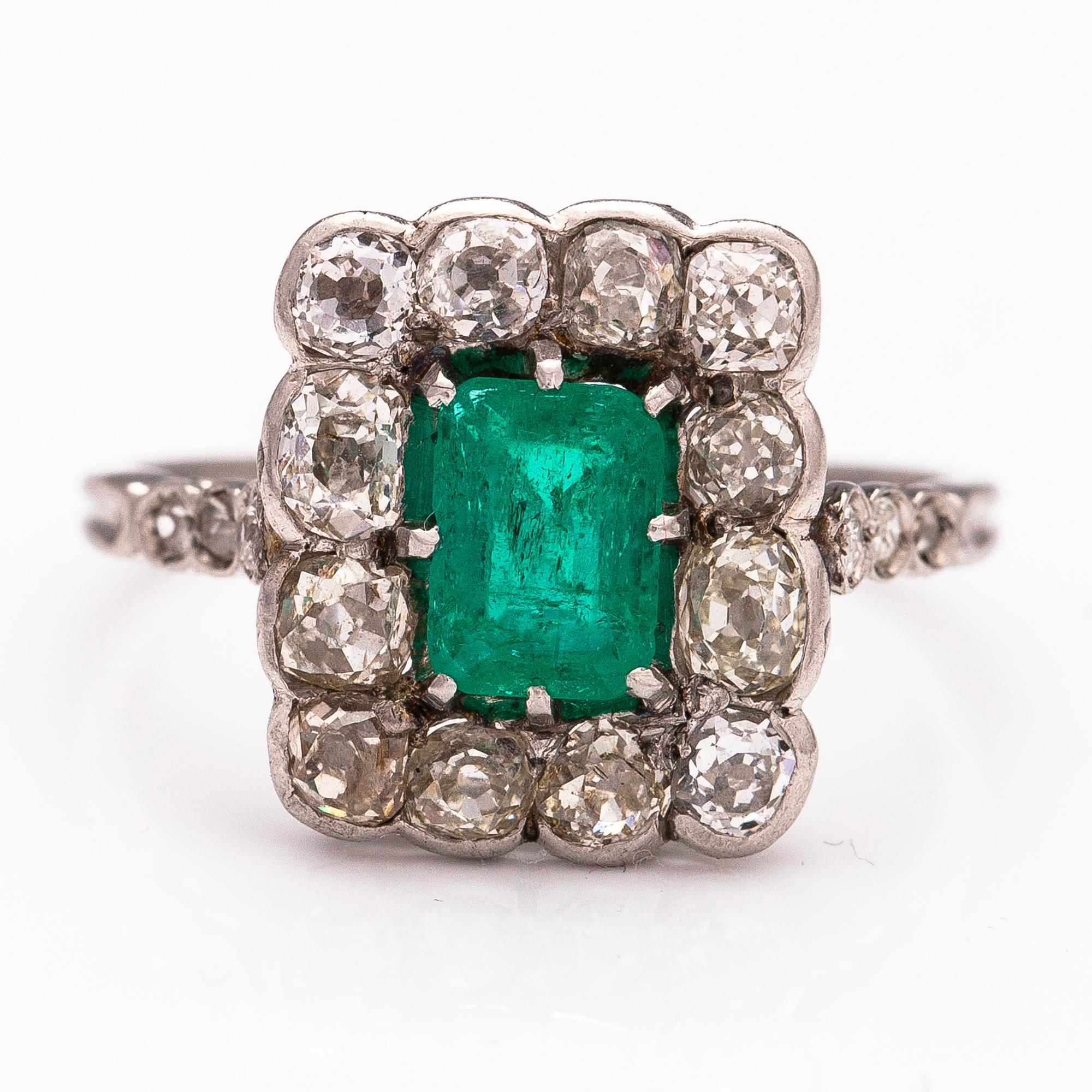 A platinum ring with an emerald ca 0.71 ct and old cut diamonds ca 1.66 ct in total.
