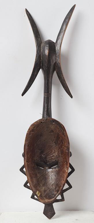 A sculptue and two masks reportedly from The Ivory coast, from the second half of the 20:th century.