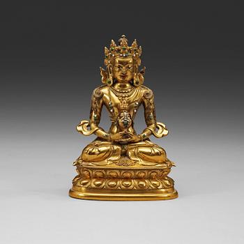 A stone inlayed gilt bronze figure of Amitayus, seated in meditation on a double lotus base, Qing dynasty, 18th Century.