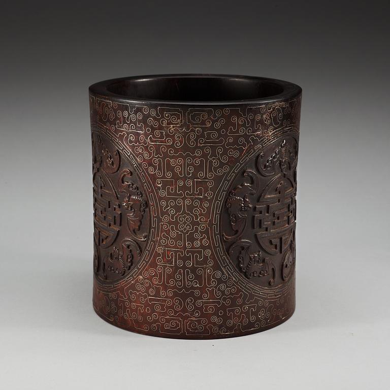 A carved wooden brush pot with metal inlay, Qing dynasty.