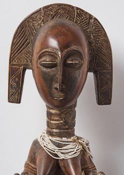 A sculptue and two masks reportedly from The Ivory coast, from the second half of the 20:th century.