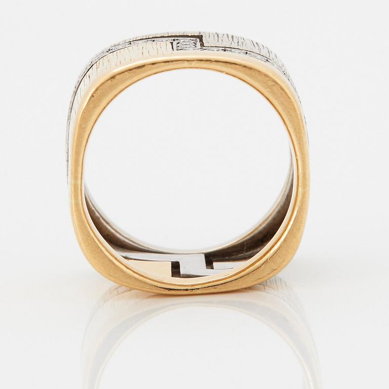 An 18K gold ring set with round brilliant-cut diamonds.