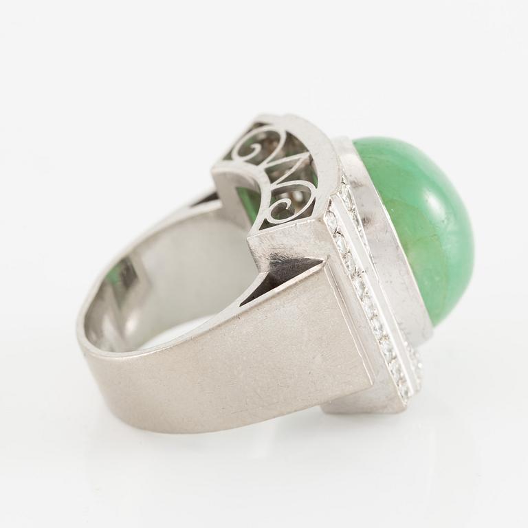 An 18K white gold ring set with a cabochon-cut emerald and round- and eight-cut diamonds.