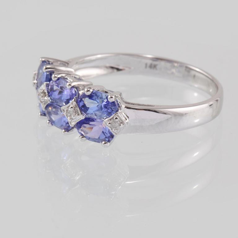 RING, 14K vitguld med 4 briljantslipade diamanter samt 6 fasettslipade tanzaniter. Vikt 2,4 gram.