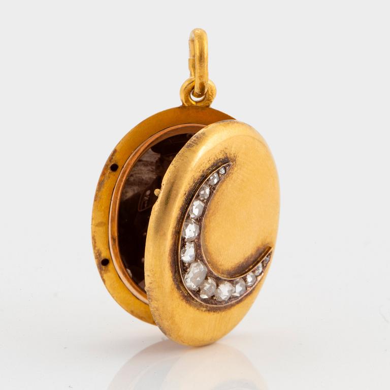 A 14K gold and rose gold locket with monogram MH in relief.