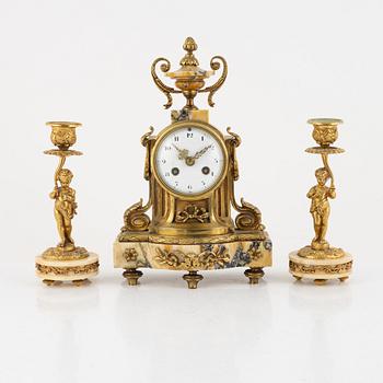 A pair of candelabras and a mantel clock, Louis XVI-style, circa 1900.