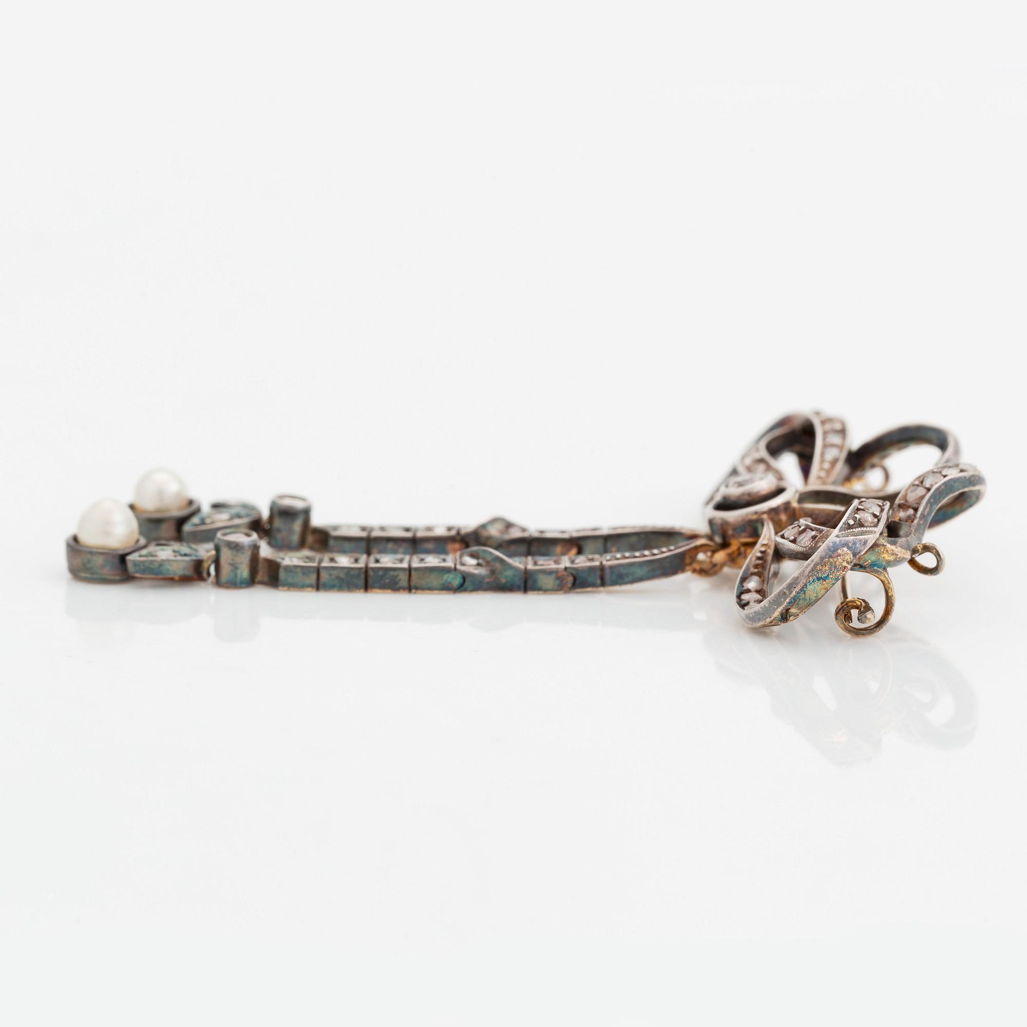 A 14K gold and silver brooch set with old- and rose-cut diamonds and two pearls.