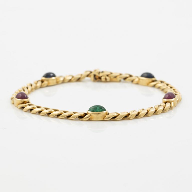 Bracelet in 18K gold set with cabochon-cut emeralds, rubies, and sapphires.