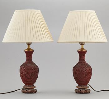 A pair of Chinese red lacquered vases, turned into table lamps, 20th century.