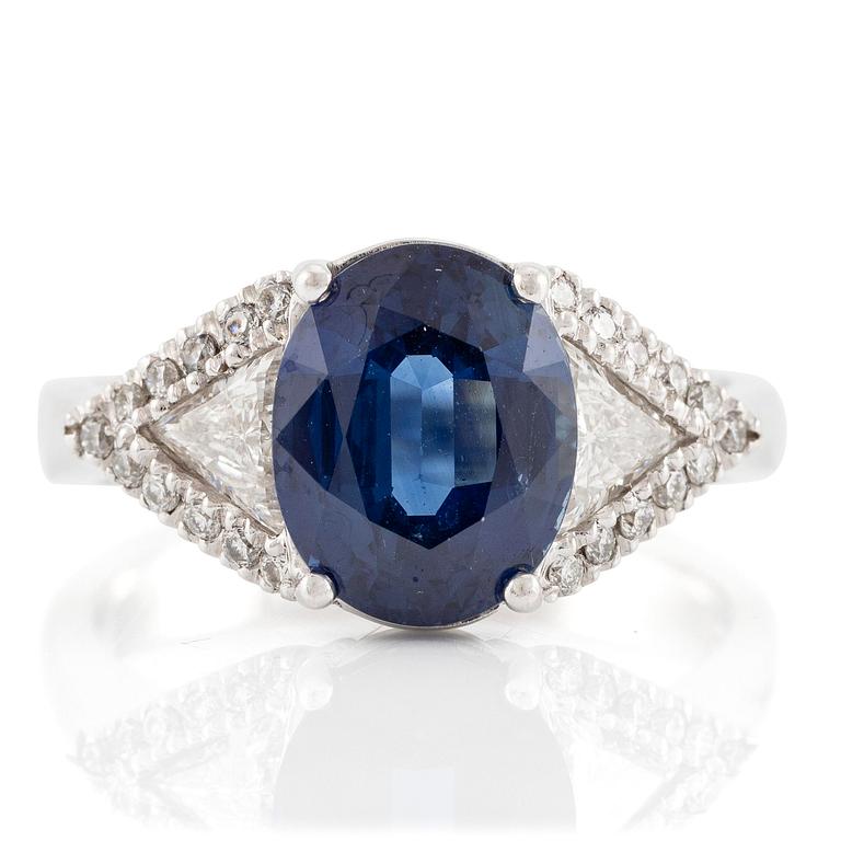 Damiani ring platina med en fasettslipad safir samt triangulära- och runda briljantslipade diamanter.