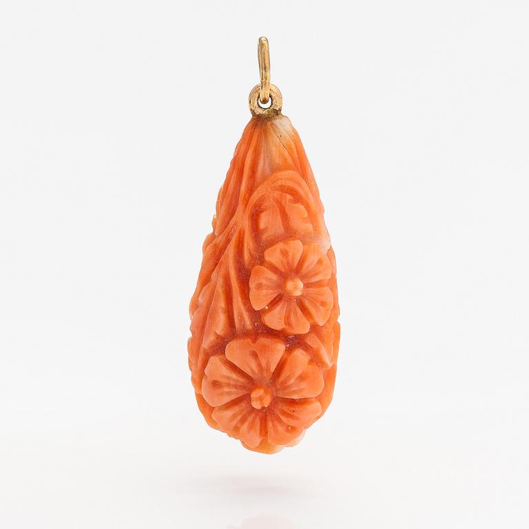 A pendant with carved coral and gold.