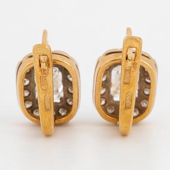 A pair of earrings in 18K gold set with emerald-cut diamonds.