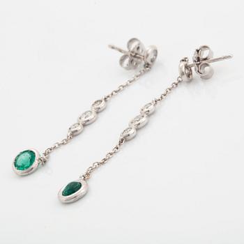 A pair of 18K white gold earrings set with faceted emeralds.
