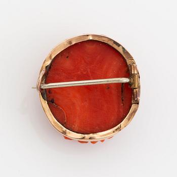 A 14K gold and coral cameo brooch.