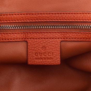 Gucci, a leather handbag.