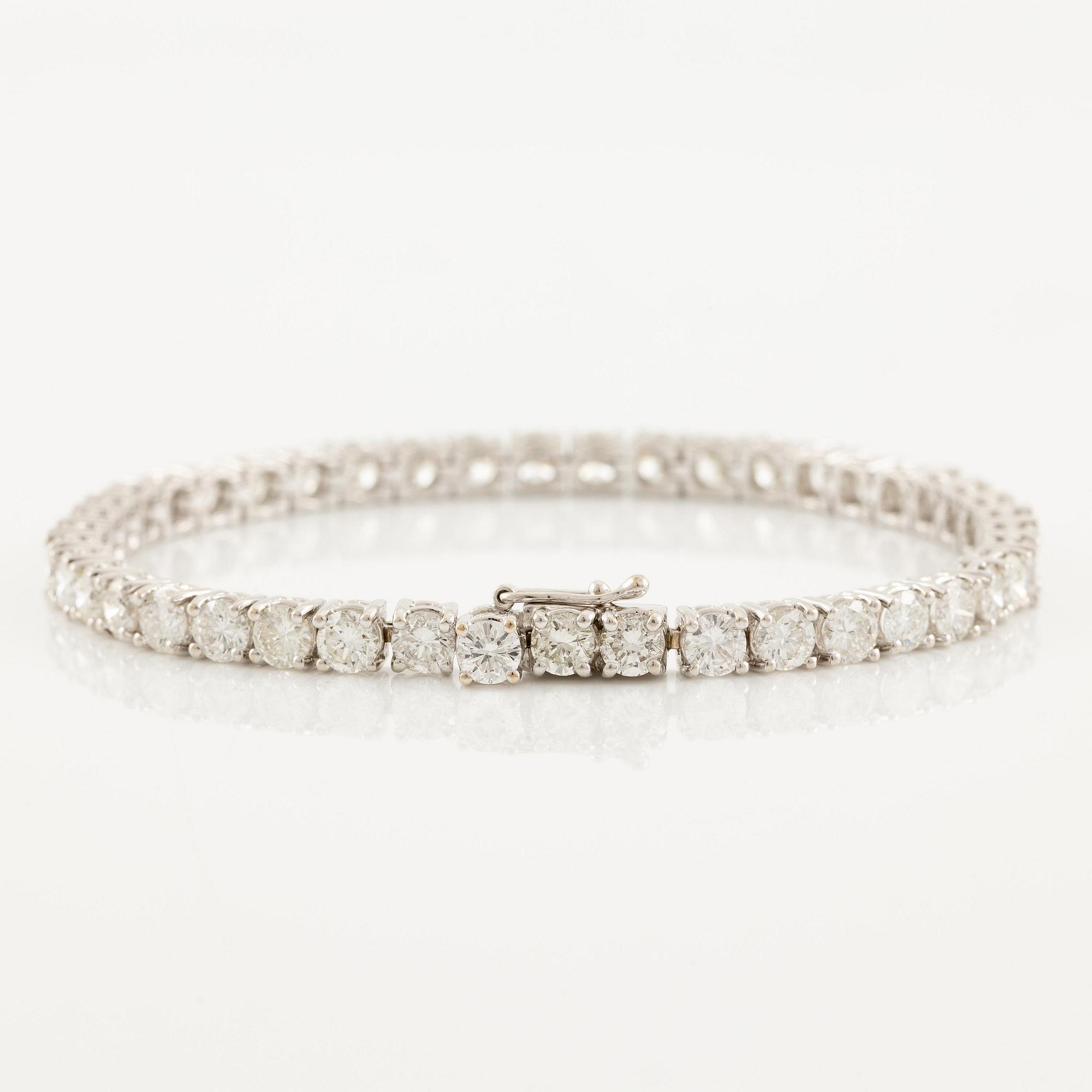 An 18K white gold tennis bracelet set with round brilliant-cut diamonds.
