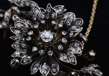 BROSCH, mittstenen antikslipad diamant ca 0.35 ct. 118 små rosenslipade diamanter. Silver på 18K guld.