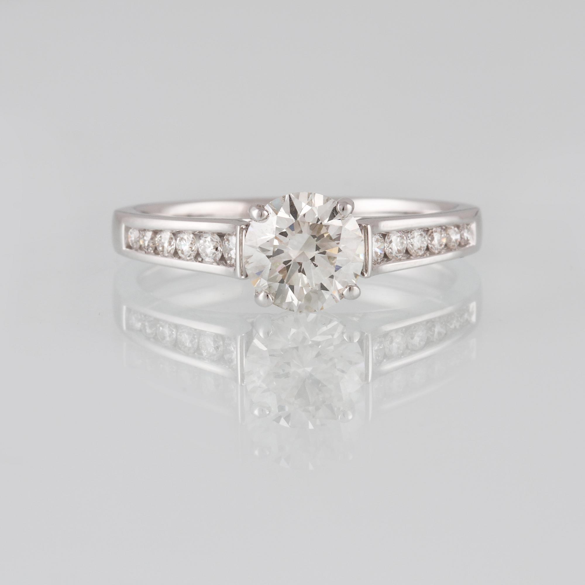 RING, 18K vitguld med briljantslipad diamant 1.01 ct samt 12 briljantslipade diamanter 0.20 ct. Vikt 3,6 gram.