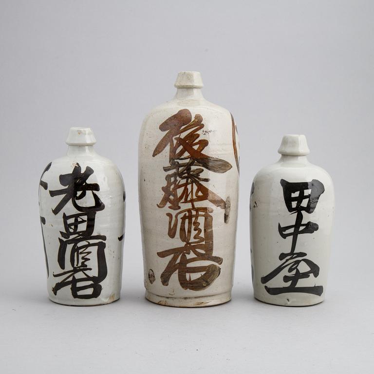 A group of twelve Japanese white glazed ceramic sake bottles, first half of the 20th century and mid 20th century.