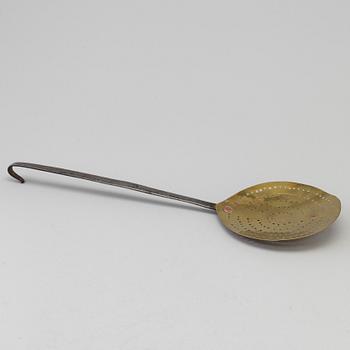 An 18th century iron and brass strainer.