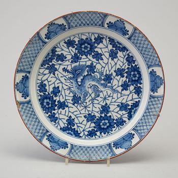 An 18th century  faience plate with blue and white chinoise style painted dragon.