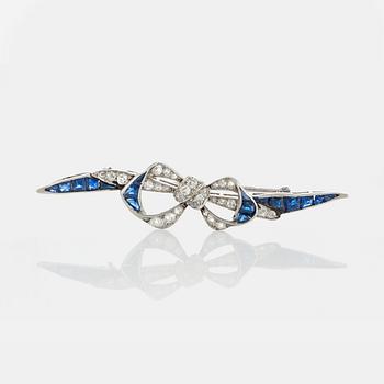 1062. A platinum brooch set with old-cut diamonds and faceted sapphires.