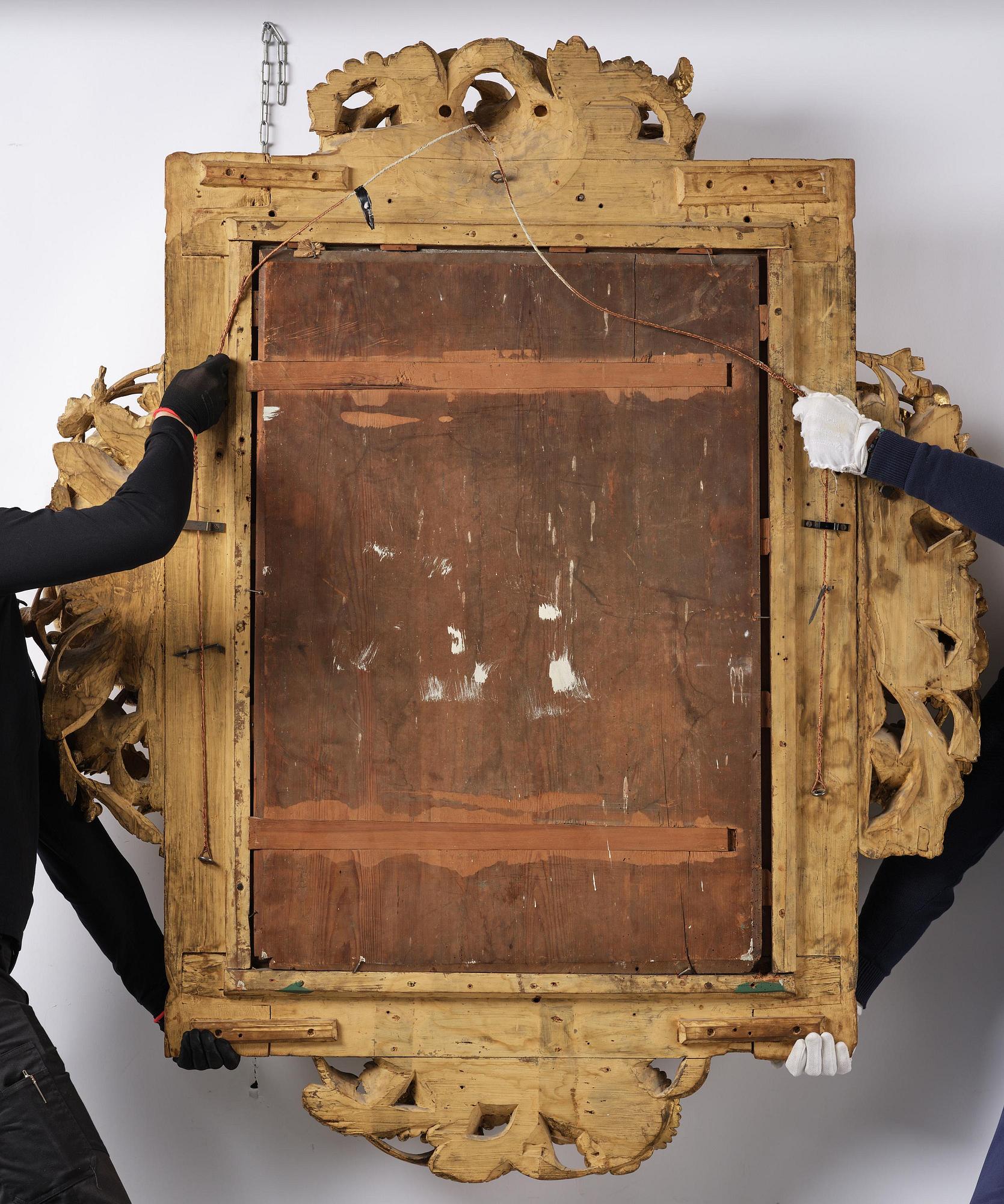 A presumably Dutch Louis XIV carved giltwood frame with mirror glass, in the style of Jean Le Pautre, late 17th century.