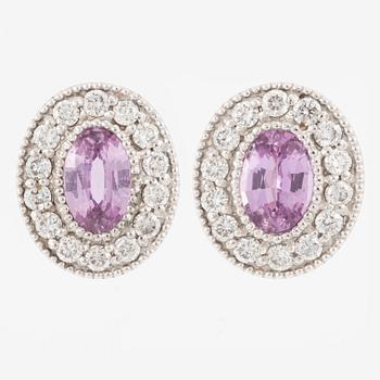 A pair of 14K gold earrings with pink faceted sapphires and round brilliant-cut diamonds.