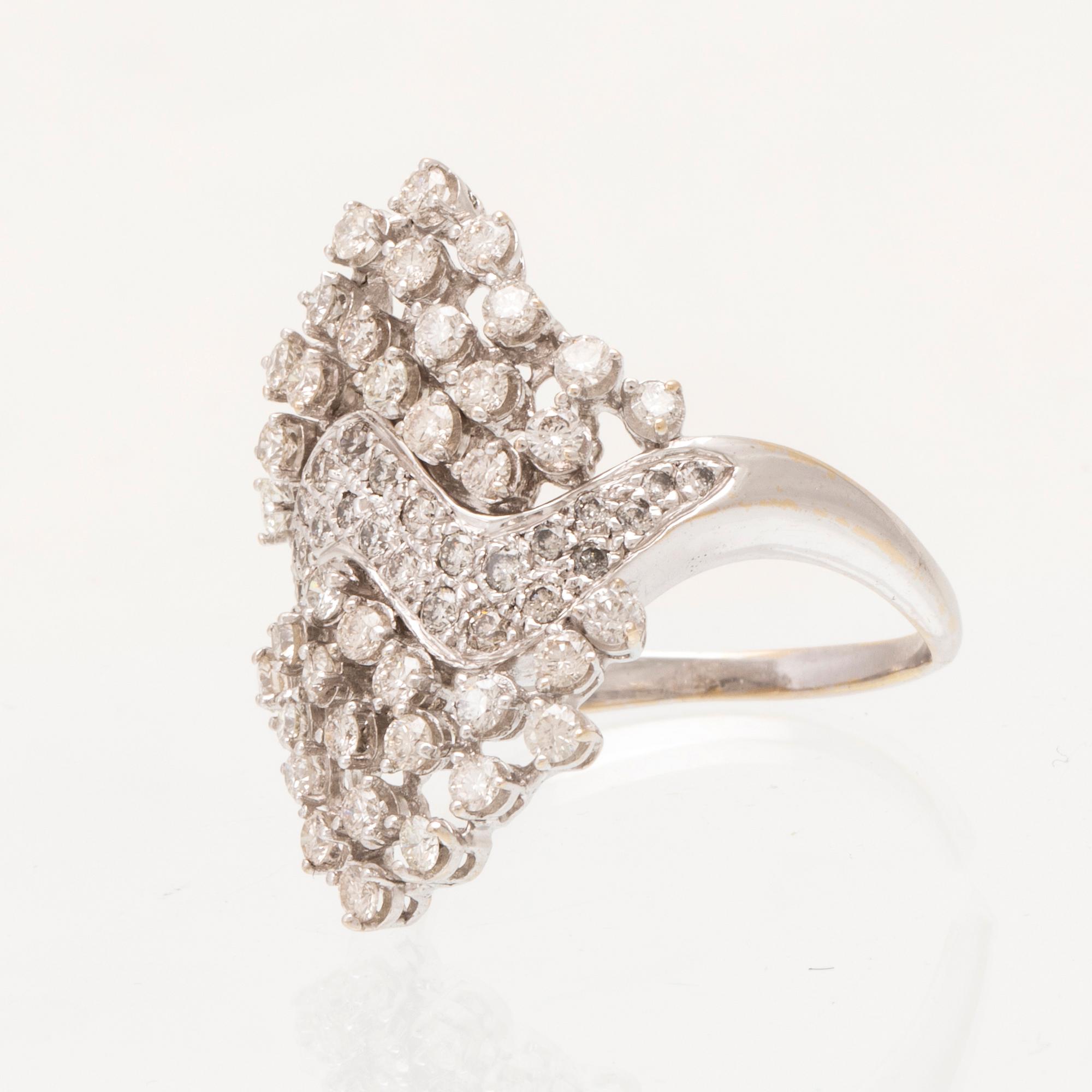An 18K white gold ring set with round brilliant cut diamonds.