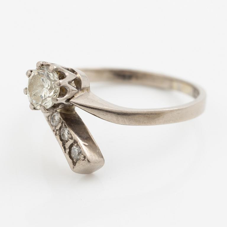 Ring, 18K vitguld med en briljantslipad diamant och  tre mindre briljantslipade diamanter.