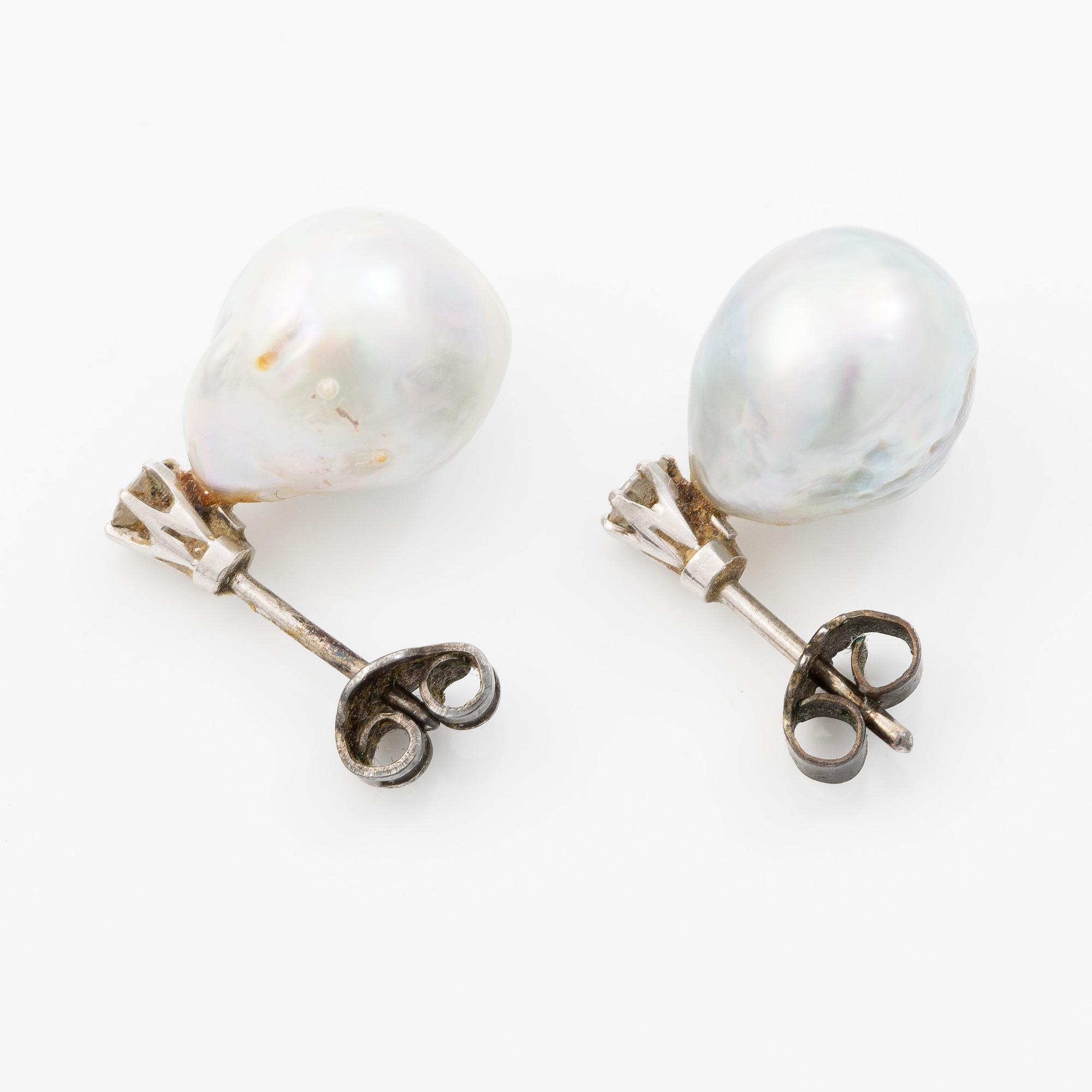 Earrings in white gold with drop-shaped grey pearls and round brilliant-cut diamonds.