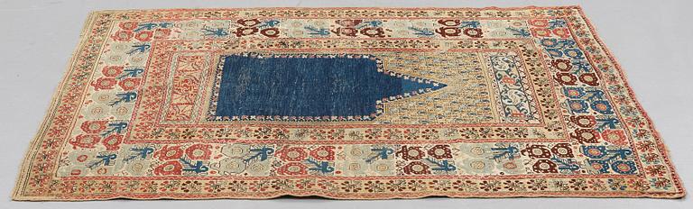A RUG, an antique Gördes (Ghiordes) prayer rug, second half of the 18th century, ca 167-170 x 120-123 cm.