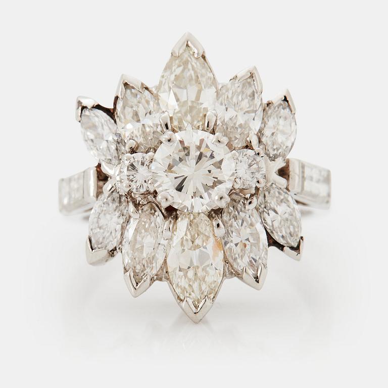 A platinum ring set with round brilliant-, navette- and baguette-cut diamonds.