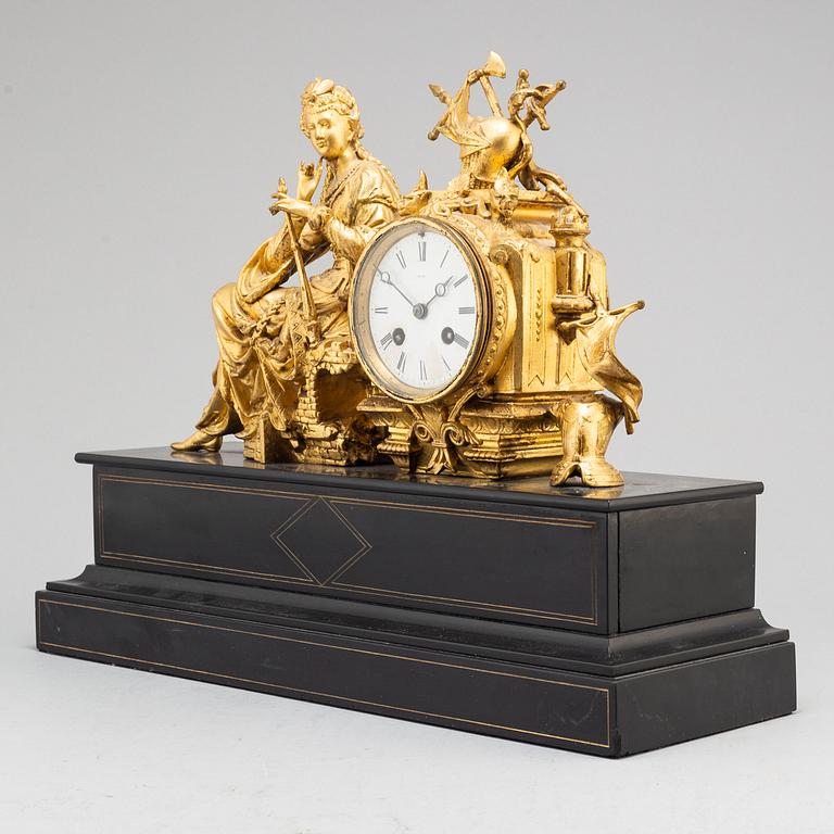 A late 19th century table clock and a pair of candlesticks.