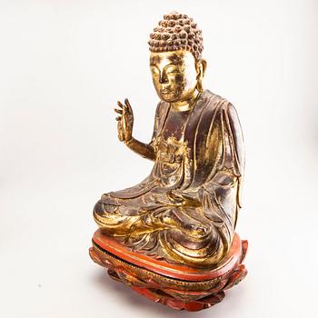 A large gilt and lacquered figure of a seated buddha, Qing dynasty, 19th Century.