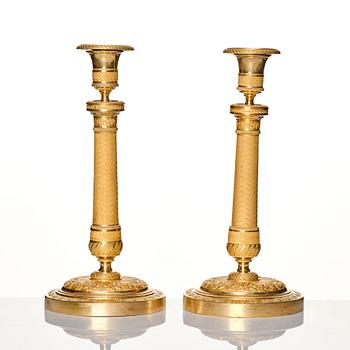 A pair of French gilded Empire candlesticks, early 19th century.