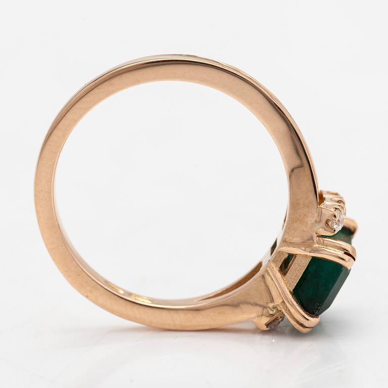 A 14K gold ring with an emerald and diamonds totalling ca. 0.12 ct.