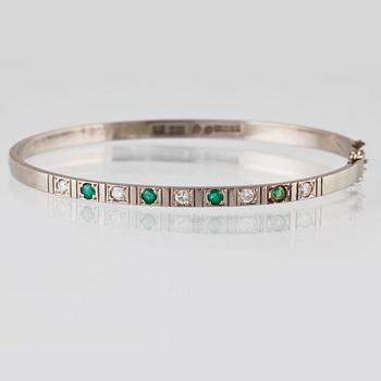 ARMRING, 18k vitguld med 5 briljantslipade diamanter och 4 smaragder, Sten Gramen, Göteborg, 1965. Vikt 13,3 gram.