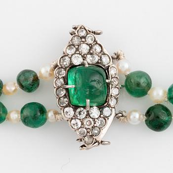 An emerald and pearl necklace with a silver clasp with a cabochon-cut emerald and old-cut diamonds.