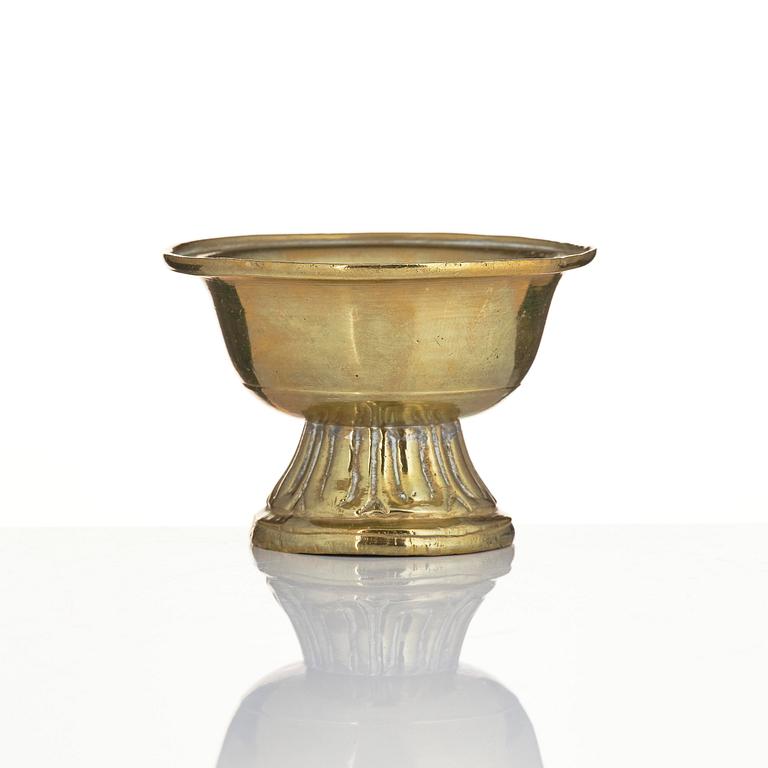A bronze deity and a brass sacrificial bowl, Tibet, circa 1900.