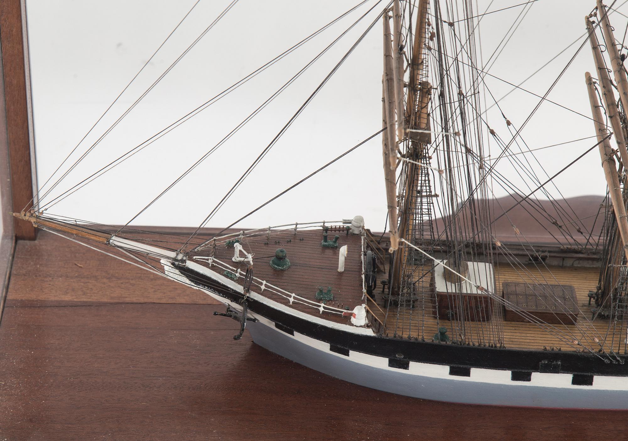 A model of a sailing ship with four masts in a glass and mahogany box by Gustav Sixten Wiman, 20th century.